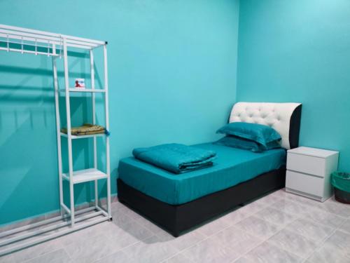 um quarto com uma cama com uma parede azul em Villa Tamu Dr Din - Pool OR Soopa Doopa em Rantau Panjang