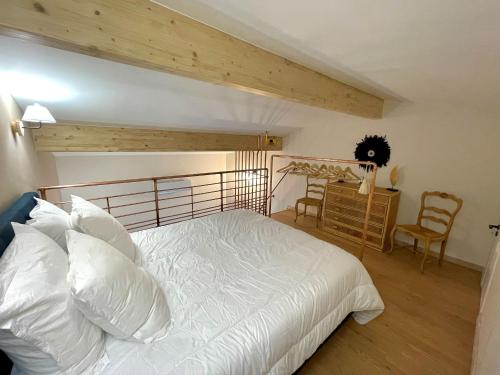 een slaapkamer met een wit bed en een tafel en stoelen bij Meublé de tourisme 4 étoiles Logis Riquet proche de Carcassonne in Caux-et-Sauzens