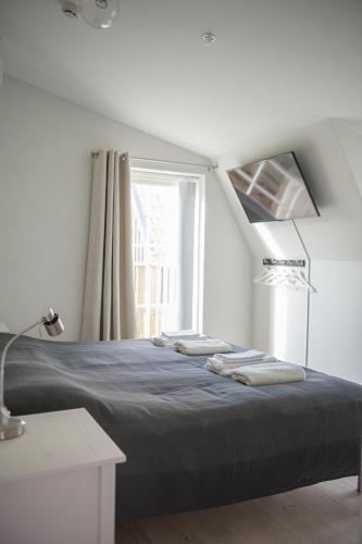 a bedroom with a large bed with a window at Mullbärsgårdens Bed and Breakfast in Visby