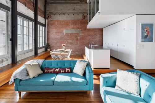 a living room with a blue couch and a table at Radiant Richmond Warehouse in Melbourne