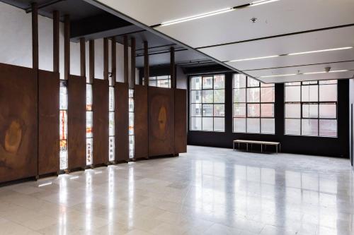 a large room with windows and a white floor at Radiant Richmond Warehouse in Melbourne
