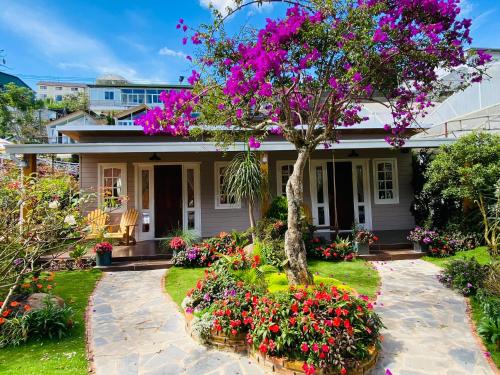 una casa con flores delante en Berry Valley Homestay, en Da Lat