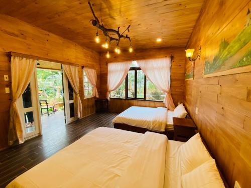 a bedroom with two beds in a wooden cabin at Berry Valley Homestay in Da Lat