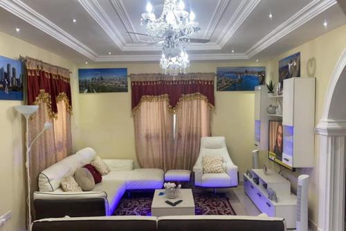 a living room with a couch and a chandelier at Janha's Senegambia Villa Holiday Rental With Free Wifi in Amdalai