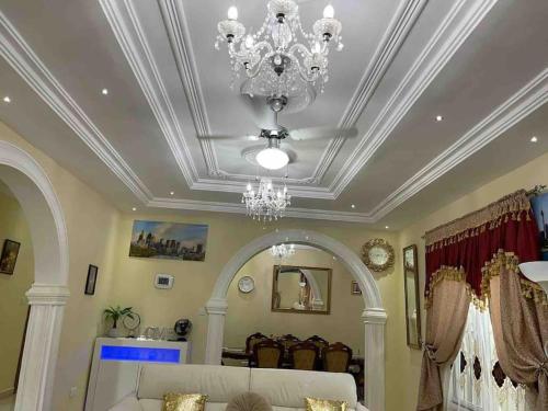 a living room with a ceiling with a chandelier at Janha's Senegambia Villa Holiday Rental With Free Wifi in Amdalai