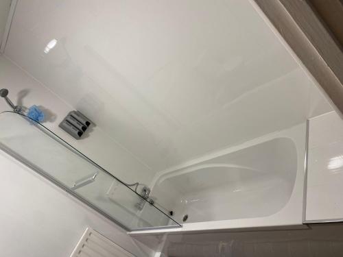 a white bathroom with a glass shelf on the ceiling at The Vacationers - Pvt Rooms with Shared Bath in Sunderland