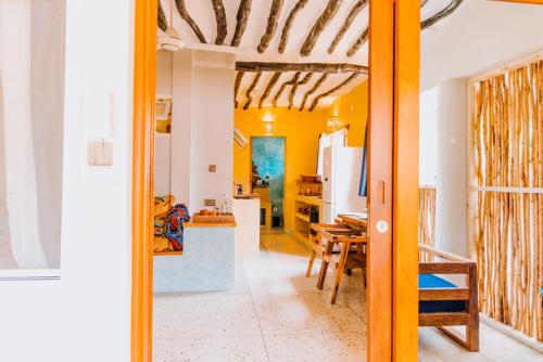 a kitchen and dining room with yellow walls at Mkunguni Villas in Bwejuu