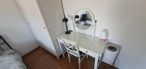 a bedroom with a white desk with a mirror at Guest house Eolea in Biser