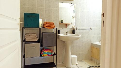 a bathroom with a sink and a toilet and a mirror at Bleu Azur 7 in Saint-Pierre