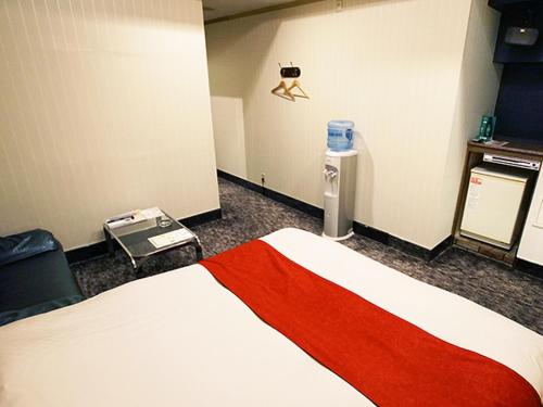 Cette chambre comprend un grand lit avec une couverture rouge. dans l'établissement フラミンゴ　大人専用, à Yoshioka