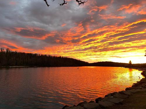 a sunset over a large body of water at Conjola Inn-let - Self Contained Unit - Lake Conjola in Manyana