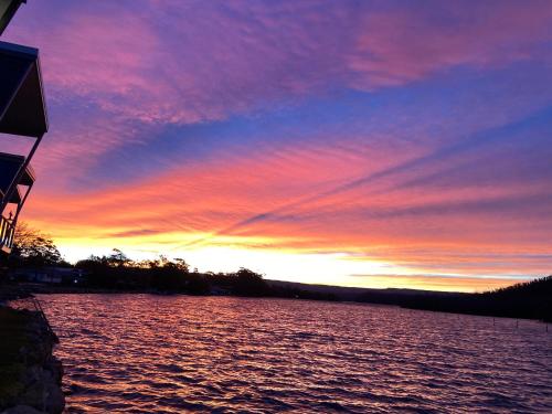 a sunset over a large body of water at Conjola Inn-let - Self Contained Unit - Lake Conjola in Manyana