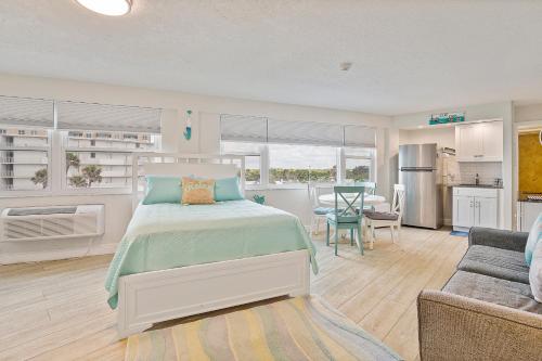 Beach Views by Day , Star Gazing by Night - Hawaiian Inn Beach Resort في Daytona Beach Shores: غرفة نوم مع سرير وغرفة معيشة