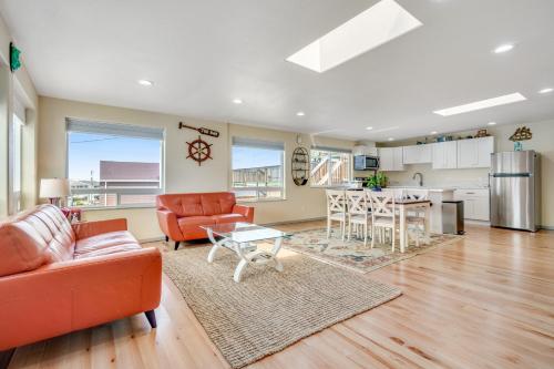 a living room with orange furniture and a kitchen at Ebb Tide in Lincoln City