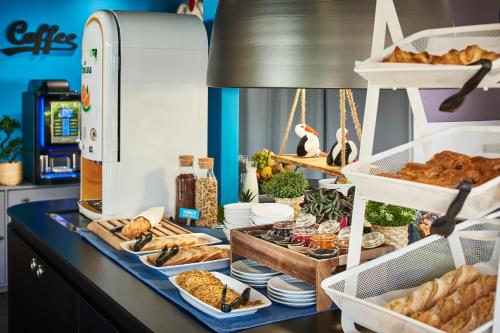 a buffet with bread and other food on a counter at Kyriad Direct Strasbourg Ouest - Zénith in Strasbourg