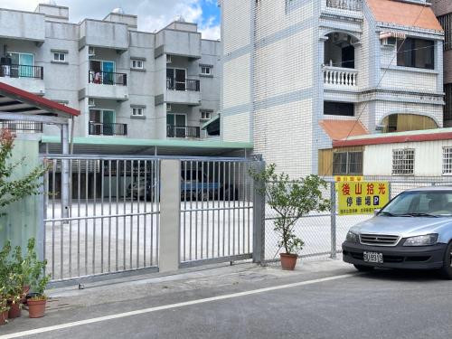 a car parked next to a fence in front of a building at Hometown Times Homestay in Yuli