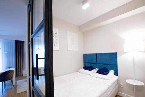 1 dormitorio con 1 cama con cabecero azul en Apartament Golden View - Rewal Morska 1 en Rewal