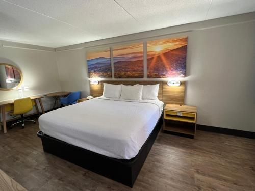 a hotel room with a large bed and a desk at Days Inn by Wyndham Birmingham/West in Birmingham