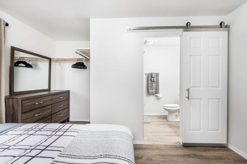 1 dormitorio con puerta blanca y baño en AlohAlaska Downstairs Suite, en Girdwood