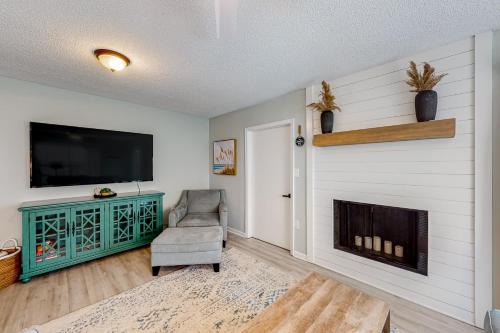a living room with a fireplace and a television at Sugar Reef Cottage-356 Billfish unit #1 in Fort Walton Beach