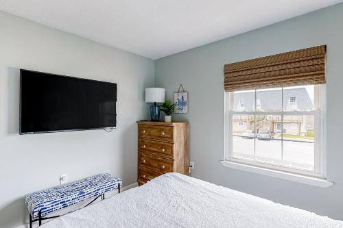 a bedroom with a bed and a flat screen tv at Sugar Reef Cottage-356 Billfish unit #1 in Fort Walton Beach