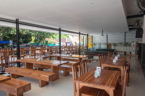 an empty restaurant with wooden tables and chairs at Central Inn Senggigi in Senggigi