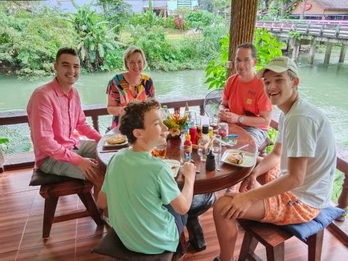 een groep mensen die rond een tafel eten bij Khao Sok River & Jungle Resort in Khao Sok