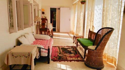 博尔普尔Nibhriti Guest House的带沙发、桌子和椅子的客厅