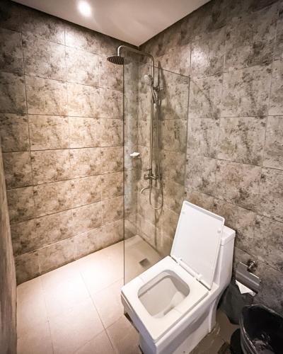 a bathroom with a toilet and a glass shower at Navarro Hotel in Caticlan