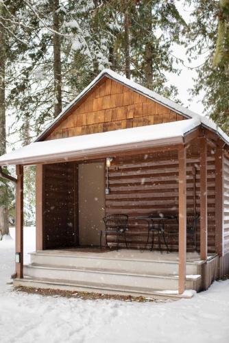 a cabin with a table and chairs in the snow at Lochsa Lodge in Lolo