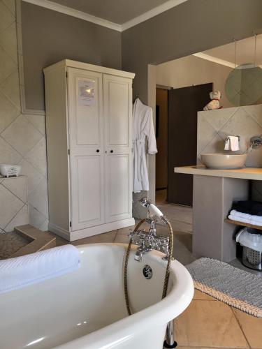 ein Badezimmer mit einer Badewanne und einem Waschbecken in der Unterkunft Perle Du Cap in Paarl