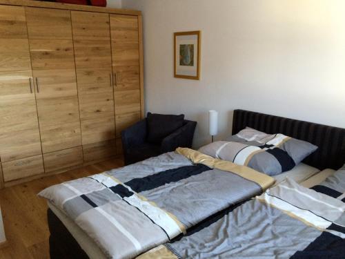 ein Schlafzimmer mit 2 Betten und einem Stuhl darin in der Unterkunft Walchensee-Idyll in Walchensee