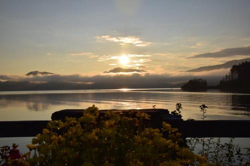 a sunset over a body of water with clouds in the sky at Walchensee-Idyll in Walchensee