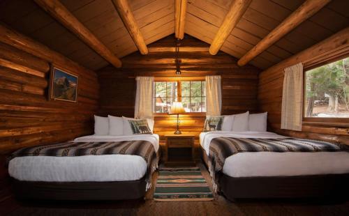 a bedroom with two beds in a log cabin at Lochsa Lodge in Lolo