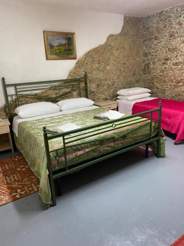 B&b il Vico في Tarsia: غرفة نوم بسرير في جدار حجري
