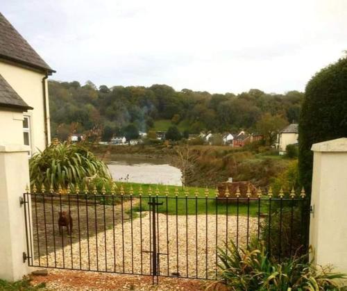 un cancello di fronte a una casa con un corpo d'acqua di Quaint little guest suite with private parking a Newport