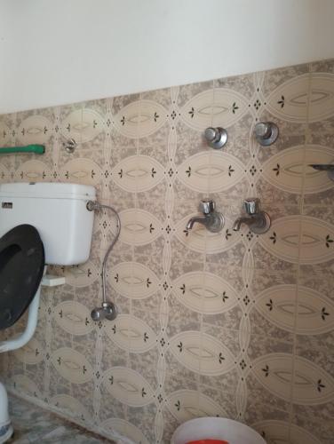 uma casa de banho com uma parede em azulejo e um lavatório. em Gomang guest house Leh em Leh
