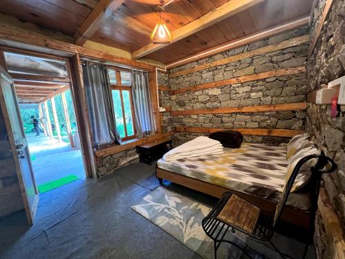 um quarto com uma cama e uma parede de tijolos em Yalakhom em Kalgha