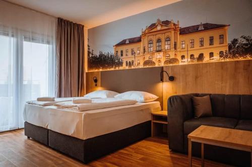 um quarto de hotel com uma cama e um sofá em Hotel Am Sachsengang em Groß-Enzersdorf