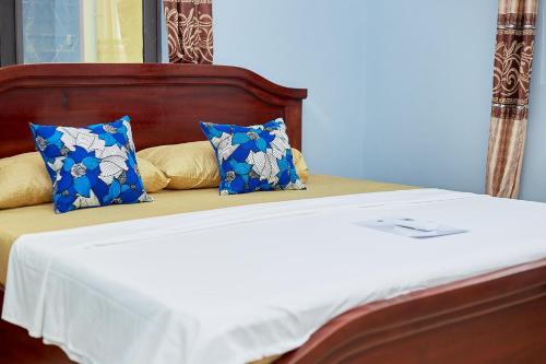 a bed with blue and white pillows on it at Indigo cottage and Apartment in Kumasi