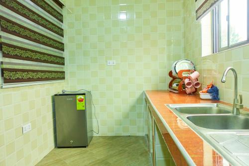 cocina con fregadero y nevera pequeña en Indigo cottage and Apartment, en Kumasi