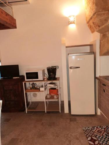 a kitchen with a refrigerator and a microwave at Casa vacanze salento Vicosoluna in Morciano di Leuca