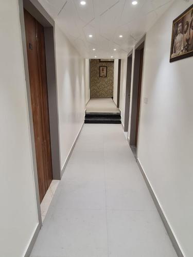 a hallway with a long white floor in a building at City View With Garden -5 Mins Walk From GOLDEN TEMPLE in Amritsar