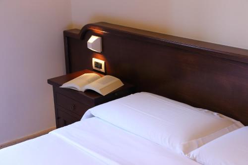 a bedroom with two beds and a wooden headboard at Casa I Cappuccini in Rome