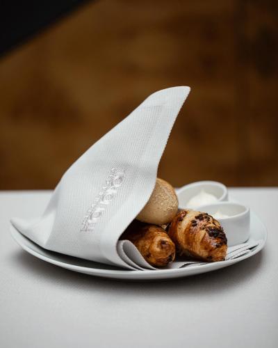 a plate with a napkin and some food on a table at Hotel Monopol in Katowice