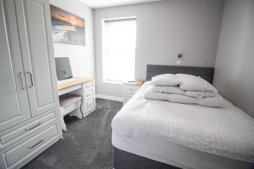 um quarto com uma cama e uma secretária com um computador em Beautiful 4 Berth Seaside Apartment In Great Yarmouth, Norfolk Ref 99006s em Great Yarmouth
