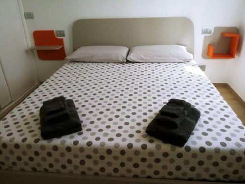 un letto con due asciugamani neri sopra di Casa Artemisia a Chiavari