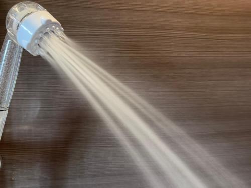 a shower head with water coming out of it at 暖炉之宿 コンセプトハウス星田 in Katano