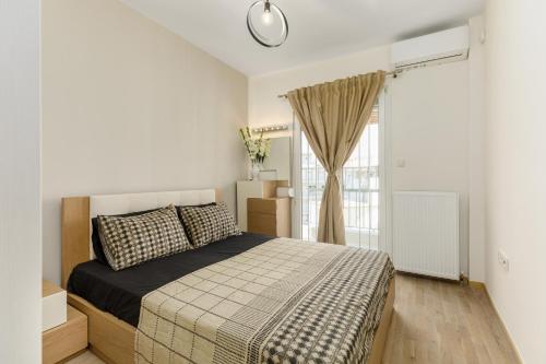 a bedroom with a bed and a window at Central Luxury Apartment in Thessaloniki