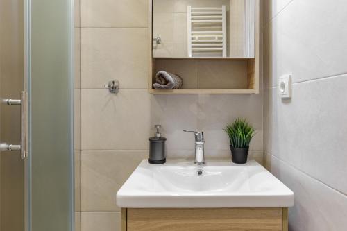 ein Bad mit einem Waschbecken und einem Spiegel in der Unterkunft Central Luxury Apartment in Thessaloniki